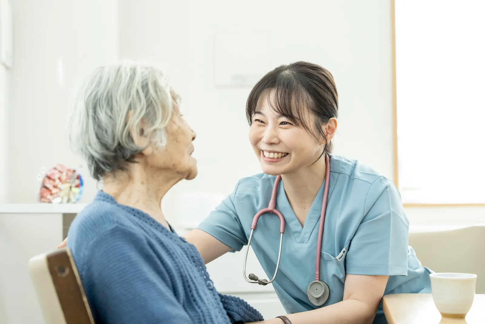看護師が利用者さまと笑顔で会話する様子