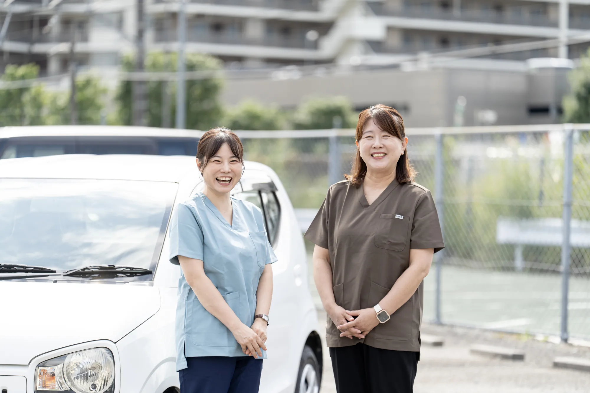 社用車の前に並ぶ、陽和のスタッフ2名