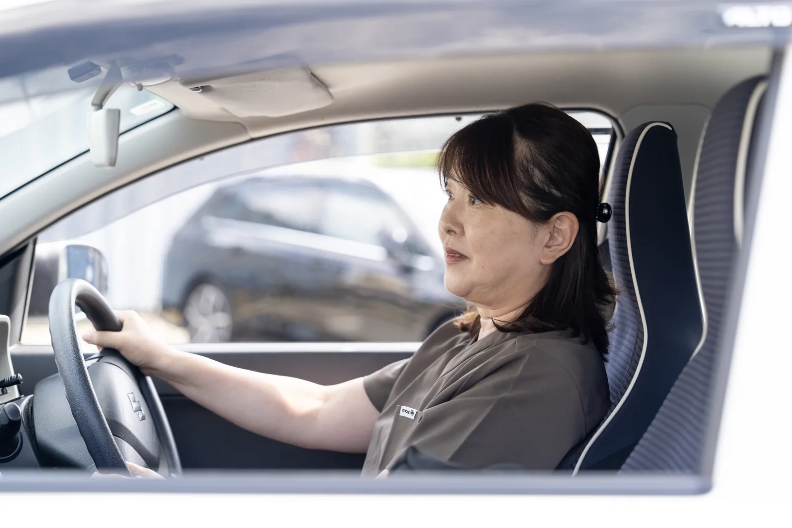 社用車を運転して訪問に向かう看護師